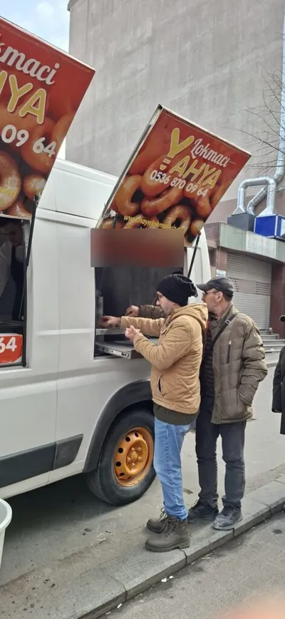 Lokma arabasının servis penceresinde sırasını bekleyenler